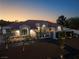 Stunning home exterior with a tile roof, arched windows, and meticulously landscaped front yard at twilight at 1429 Iron Hills Ln, Las Vegas, NV 89134