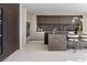 Modern kitchen featuring dark wood cabinetry, a marble island with seating, and luxury appliances at 1429 Iron Hills Ln, Las Vegas, NV 89134