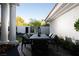 Outdoor patio with a table and chairs, complemented by lush greenery, and white pillars at 1429 Iron Hills Ln, Las Vegas, NV 89134