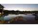 Serene twilight view of the backyard pool, spa, and lush landscaping of the property at 1429 Iron Hills Ln, Las Vegas, NV 89134