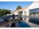 Beautiful backyard pool and spa area with a patio and lush landscaping surrounding the property at 1429 Iron Hills Ln, Las Vegas, NV 89134