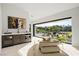 Bright, modern sitting area features an adjacent wet bar and glass doors to the backyard at 1429 Iron Hills Ln, Las Vegas, NV 89134