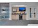 Wet bar area with modern cabinets, a built-in fridge, and a wall-mounted TV for entertaining at 145 E Harmon Ave # 3705, Las Vegas, NV 89109