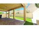 A covered back patio with brick pavers has a view of the backyard's artificial turf lawn at 145 Forest Crossing Ct, Las Vegas, NV 89148