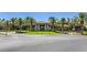 Palm tree lined driveway leading to a beautiful clubhouse with manicured landscaping at 145 Forest Crossing Ct, Las Vegas, NV 89148