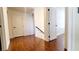 A brightly lit hallway with hardwood floors is flanked by white walls and doors at 145 Forest Crossing Ct, Las Vegas, NV 89148