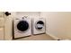 A clean laundry room has a washer and dryer with a cabinet above at 145 Forest Crossing Ct, Las Vegas, NV 89148