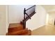 A staircase with hardwood treads, a black bannister, and white walls is showcased at 145 Forest Crossing Ct, Las Vegas, NV 89148