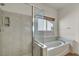 Bathroom featuring a glass-enclosed shower and soaking tub with tile surround at 1604 Lazy Hill Ranch Way, North Las Vegas, NV 89081
