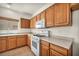 Bright kitchen featuring wood cabinets, an island, and modern white appliances at 1604 Lazy Hill Ranch Way, North Las Vegas, NV 89081