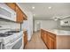 Bright kitchen featuring wood cabinets, an island, and modern white appliances at 1604 Lazy Hill Ranch Way, North Las Vegas, NV 89081