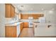 Bright kitchen featuring wood cabinets, an island, and modern white appliances at 1604 Lazy Hill Ranch Way, North Las Vegas, NV 89081