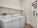 This laundry room features a washer, a dryer, shelving, and a window at 1604 Lazy Hill Ranch Way, North Las Vegas, NV 89081