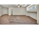 Spacious living room featuring neutral walls, large windows, ceiling fan and tile/carpet flooring at 1604 Lazy Hill Ranch Way, North Las Vegas, NV 89081