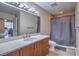 Bathroom features a modern vanity, granite countertops, and tiled shower with curtain at 200 W Sahara Ave # 2210, Las Vegas, NV 89102