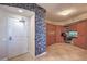 Inviting entryway featuring a tiled floor, storage cabinet, and a stylish brick accent wall at 200 W Sahara Ave # 2210, Las Vegas, NV 89102