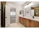 Bright bathroom with double sinks, quartz countertops, wood cabinets, and a luxurious walk-in shower at 2149 Kelsey Creek Ct, Henderson, NV 89044
