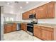 Modern kitchen with wood cabinets, granite counters, stainless steel appliances, and tiled flooring at 2149 Kelsey Creek Ct, Henderson, NV 89044