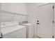 Functional laundry room with a white washer, dryer, wire shelving, and a door at 2149 Kelsey Creek Ct, Henderson, NV 89044