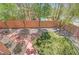 Green backyard with mature landscaping, brick accents, and a partial pool view at 229 N Buteo Woods Ln, Las Vegas, NV 89144