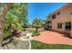 Expansive backyard featuring a patio, lush greenery, and a decorative water feature at 229 N Buteo Woods Ln, Las Vegas, NV 89144