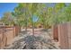 A private backyard with low-maintenance landscaping between block walls is shaded by trees at 229 N Buteo Woods Ln, Las Vegas, NV 89144