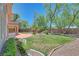 Landscaped backyard features a patio and a grassy area, perfect for outdoor activities at 229 N Buteo Woods Ln, Las Vegas, NV 89144