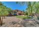 Expansive backyard featuring lush greenery, a well-manicured lawn, a patio and desert landscaping at 229 N Buteo Woods Ln, Las Vegas, NV 89144