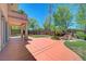 Lovely backyard with large patio, green lawn, mature trees, and a water feature at 229 N Buteo Woods Ln, Las Vegas, NV 89144
