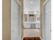 View of a bathroom with white vanity and tile flooring through an open doorway at 229 N Buteo Woods Ln, Las Vegas, NV 89144