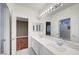Bright bathroom featuring double sinks, a large mirror, and a shower/tub combo at 229 N Buteo Woods Ln, Las Vegas, NV 89144