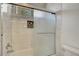 Tiled shower and tub featuring glass doors and a decorative tile niche at 229 N Buteo Woods Ln, Las Vegas, NV 89144
