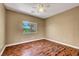 Comfortable bedroom with hardwood floors, ceiling fan, and window with outdoor view at 229 N Buteo Woods Ln, Las Vegas, NV 89144