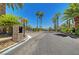 Gated community entrance is lined with palm trees and manicured landscaping at 229 N Buteo Woods Ln, Las Vegas, NV 89144