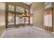 Elegant dining room with stone tile floors, chandelier, and large windows with decorative curtains overlooking the backyard at 229 N Buteo Woods Ln, Las Vegas, NV 89144