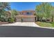 Charming two-story home with a three-car garage, desert landscaping, and a well-maintained lawn at 229 N Buteo Woods Ln, Las Vegas, NV 89144