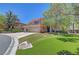 Inviting front entrance with a curved walkway, well-manicured lawn, and a view of the three-car garage at 229 N Buteo Woods Ln, Las Vegas, NV 89144
