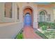 Inviting front entrance with a curved walkway, well-manicured lawn, and a view of the arched entry at 229 N Buteo Woods Ln, Las Vegas, NV 89144