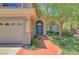Inviting front entrance with a curved walkway, well-manicured lawn, and a view of the arched entry at 229 N Buteo Woods Ln, Las Vegas, NV 89144