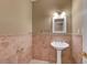 Cozy half bathroom featuring pedestal sink, decorative mirror, and complementary fixtures. Great for guests at 229 N Buteo Woods Ln, Las Vegas, NV 89144
