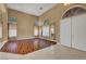 Spacious living room featuring hardwood floors, high ceilings, and large windows with decorative curtains near the front door at 229 N Buteo Woods Ln, Las Vegas, NV 89144