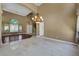 Open-concept living room featuring stone tile flooring, chandelier, high ceilings, and large windows with decorative curtains at 229 N Buteo Woods Ln, Las Vegas, NV 89144