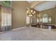 Bright living room featuring stone tile flooring, chandelier, high ceilings, and large windows with decorative curtains at 229 N Buteo Woods Ln, Las Vegas, NV 89144