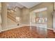 Open-concept living area with hardwood floors, high ceilings, large windows, and a staircase leading to the second floor at 229 N Buteo Woods Ln, Las Vegas, NV 89144