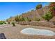 Landscaped backyard features a rock garden, retaining wall, and mature plants for privacy at 2413 Rockford St, Las Vegas, NV 89134