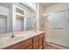 Bright bathroom featuring double sinks, a large mirror, and a glass-enclosed shower stall at 2413 Rockford St, Las Vegas, NV 89134