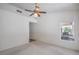 Standard bedroom featuring a ceiling fan, neutral walls and carpet, and a window viewing backyard at 2413 Rockford St, Las Vegas, NV 89134