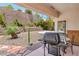 Covered patio with a grill and seating, perfect for outdoor dining and entertaining in landscaped backyard at 2413 Rockford St, Las Vegas, NV 89134