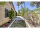 Lush backyard featuring a mix of desert landscaping, mature trees, and a concrete path, offering a tranquil retreat at 2528 Huber Heights Dr, Las Vegas, NV 89128