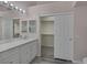 Bathroom featuring dual vanity, mirror, decorative lighting, and sliding door to the spacious closet at 2528 Huber Heights Dr, Las Vegas, NV 89128
